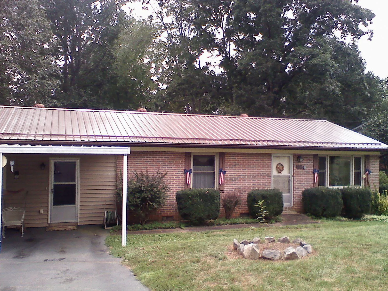 Bronze metal roof and carport on a brick ranch home — Roof Repair work by our crew in Carlisle